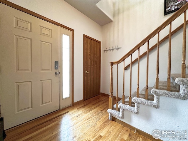 foyer entrance with stairway and wood finished floors