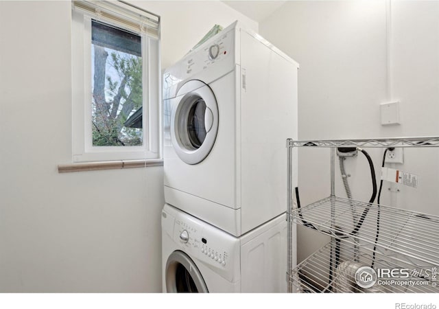 washroom with stacked washer and dryer and laundry area