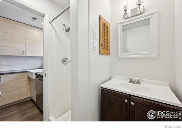 bathroom featuring visible vents, a stall shower, wood finished floors, and vanity