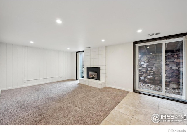 unfurnished living room featuring visible vents, a tile fireplace, tile patterned flooring, carpet floors, and recessed lighting