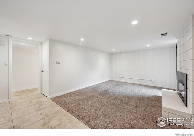 interior space with recessed lighting, a fireplace, visible vents, tile patterned floors, and carpet