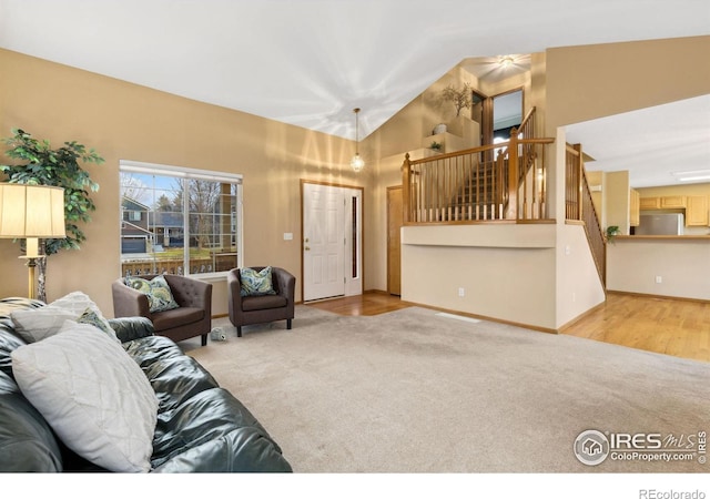 carpeted living area with stairway and baseboards