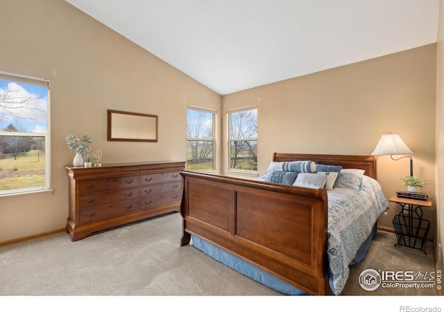 carpeted bedroom featuring baseboards and vaulted ceiling