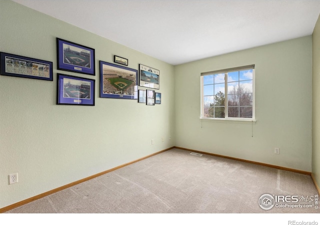 carpeted empty room with visible vents and baseboards