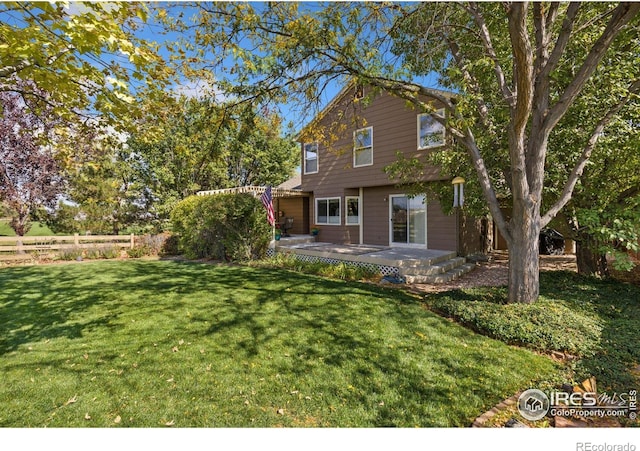 back of property featuring a yard and fence