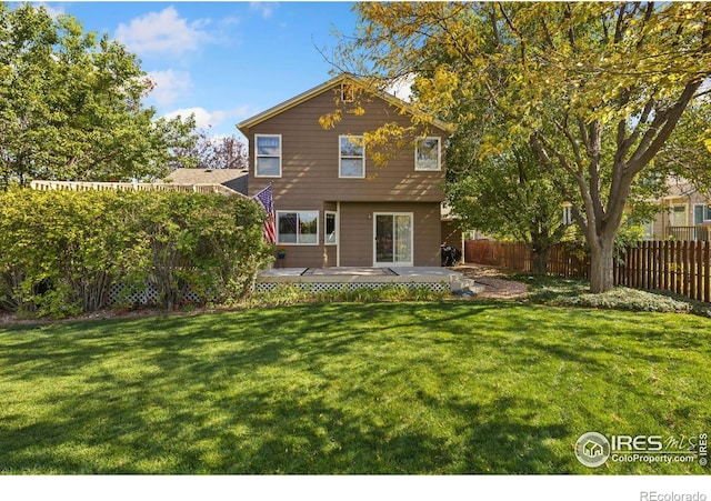 rear view of property with fence and a yard