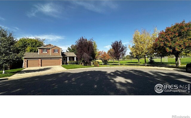 view of front facade with a garage, a front yard, and concrete driveway