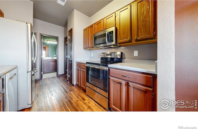 kitchen with brown cabinets, light countertops, visible vents, appliances with stainless steel finishes, and light wood-type flooring