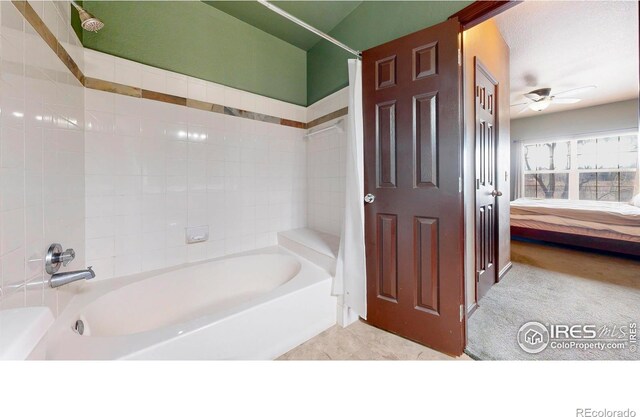 bathroom with ceiling fan, connected bathroom, and bathing tub / shower combination