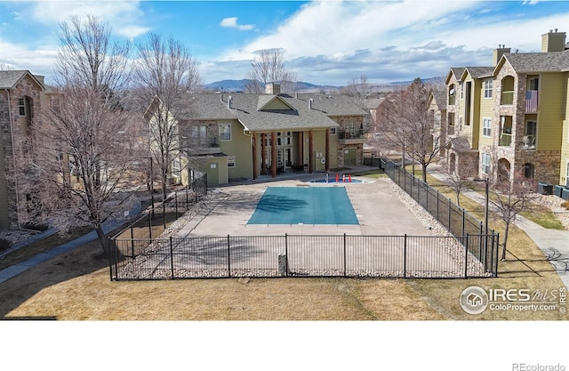 community pool featuring a patio area and fence