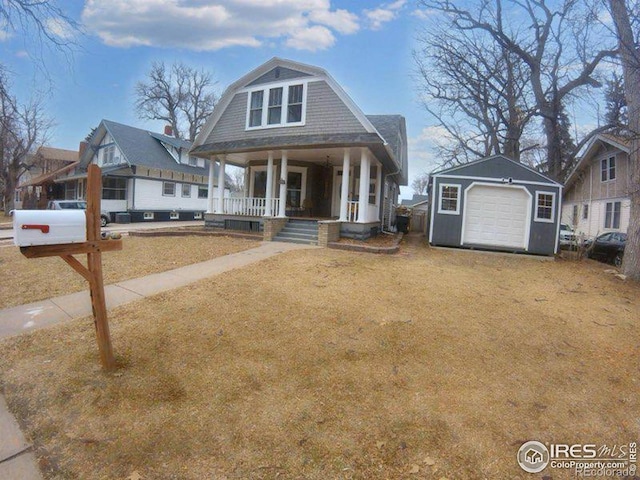 view of front of house featuring an outbuilding, covered porch, a gambrel roof, a garage, and driveway