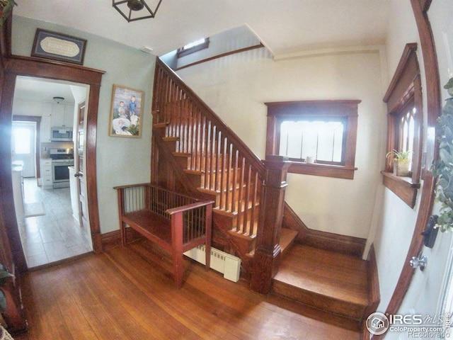 stairway with baseboards and hardwood / wood-style floors