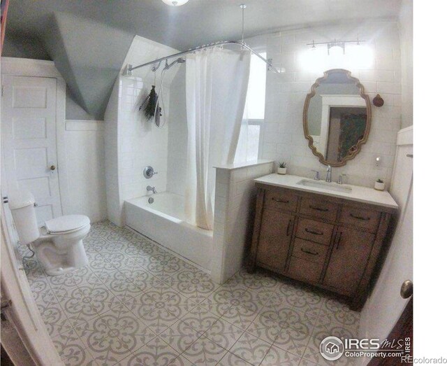 bathroom featuring toilet, shower / tub combo, tile walls, vanity, and tile patterned floors