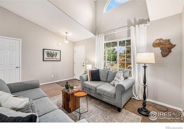 living area with high vaulted ceiling, carpet, a wealth of natural light, and baseboards