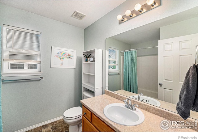 full bathroom featuring baseboards, visible vents, a shower with shower curtain, toilet, and vanity