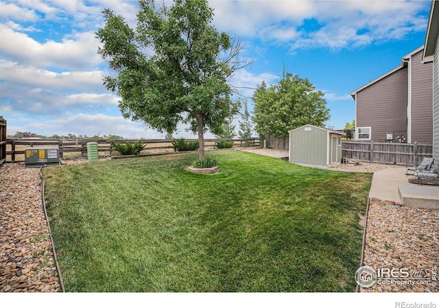 view of yard with a storage shed, a patio, an outbuilding, and a fenced backyard