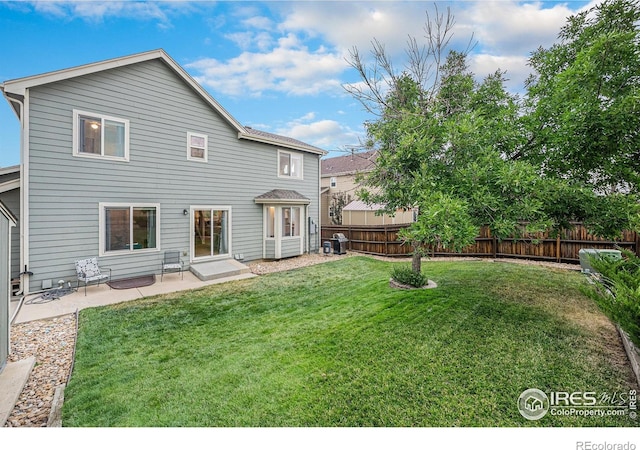 back of property with a patio area, fence, and a lawn