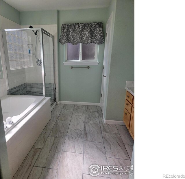 full bath featuring a shower stall, vanity, marble finish floor, and baseboards