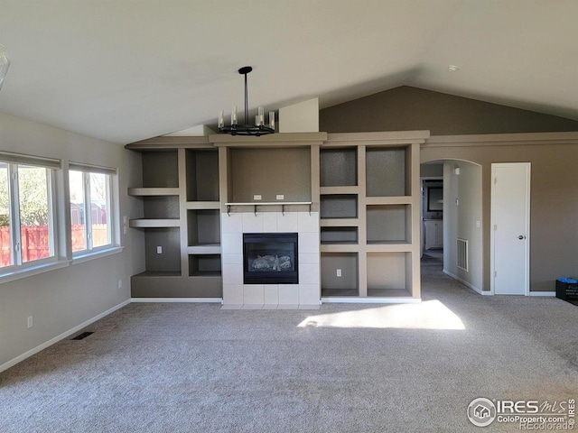unfurnished living room featuring carpet, visible vents, and vaulted ceiling