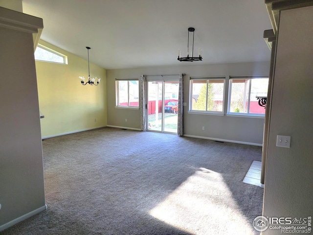 carpeted spare room featuring visible vents, baseboards, a chandelier, and vaulted ceiling
