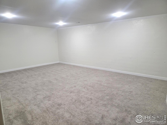 spare room with ornamental molding, baseboards, and carpet