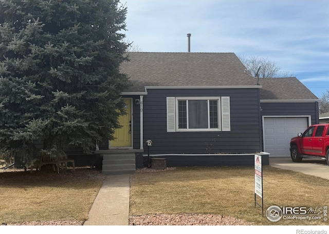 view of front of house with a front yard, an attached garage, and a shingled roof