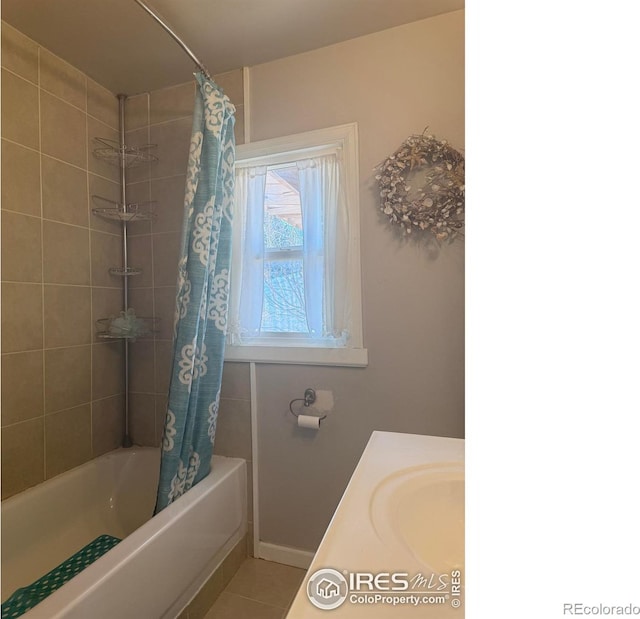 full bath with tile patterned floors, shower / bathtub combination with curtain, baseboards, and a sink