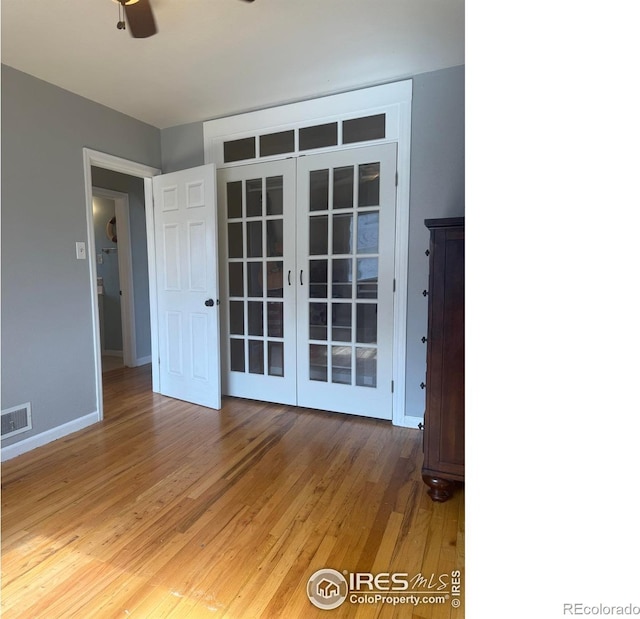 spare room featuring visible vents, baseboards, light wood-type flooring, french doors, and a ceiling fan