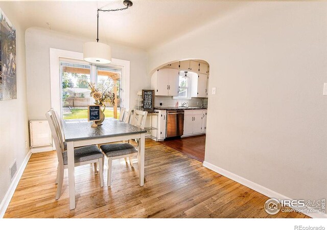 410 Cottonwood Ave, Eaton, CO 80615 - dining area featuring light wood finished floors, baseboards, and arched walkways