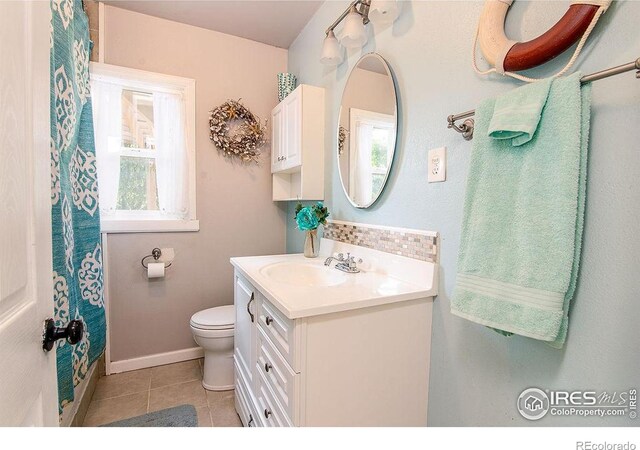 410 Cottonwood Ave, Eaton, CO 80615 - bathroom featuring vanity, toilet, tile patterned floors, decorative backsplash, and baseboards