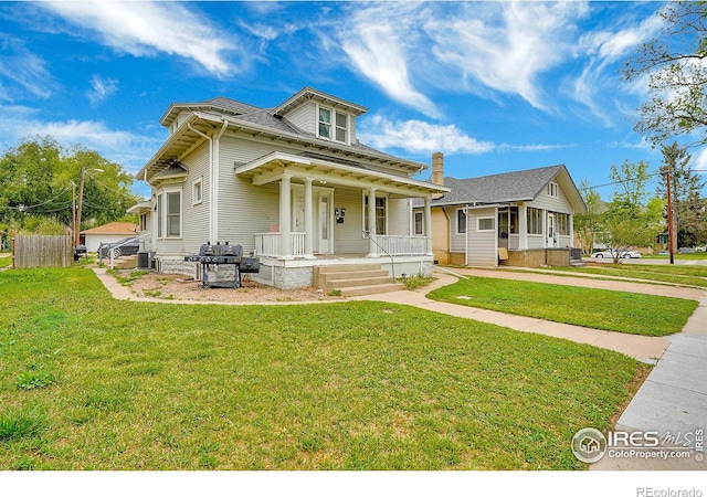 view of front of home with central AC unit, a front lawn, and a porch