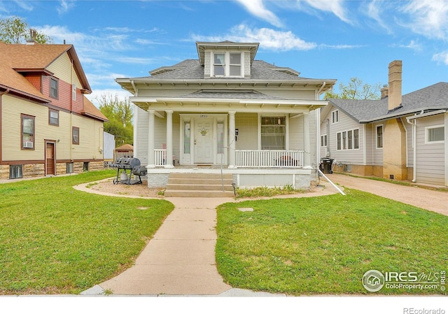 view of front of property featuring covered porch, a front lawn, and roof with shingles