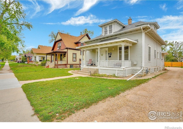 view of front of property with a chimney, a front lawn, and a porch