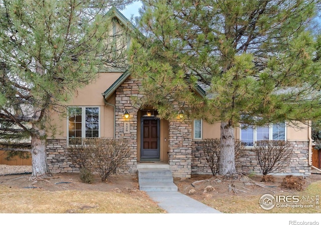 view of front of property featuring stone siding and stucco siding