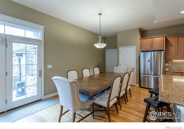 dining space with baseboards and light wood finished floors