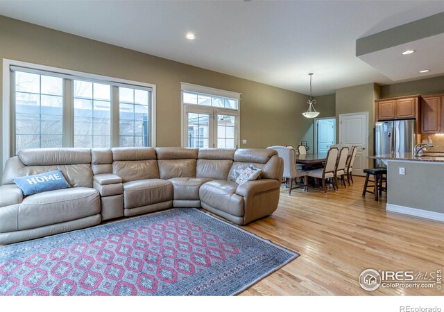 living area featuring light wood-style flooring and recessed lighting