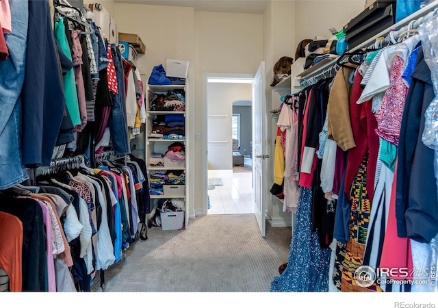 spacious closet featuring arched walkways and carpet floors