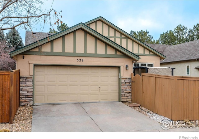 view of front of home with stone siding, fence, and stucco siding