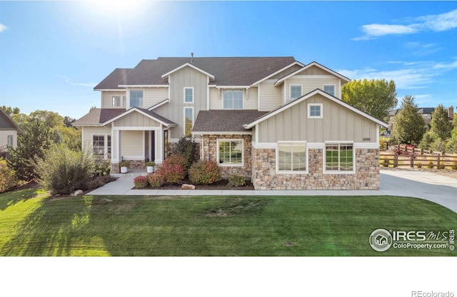 craftsman house with a front lawn, board and batten siding, and a shingled roof