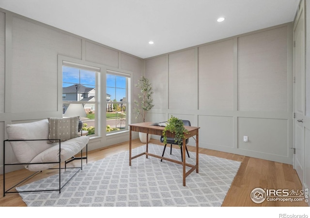 office space with recessed lighting, light wood-style flooring, and a decorative wall