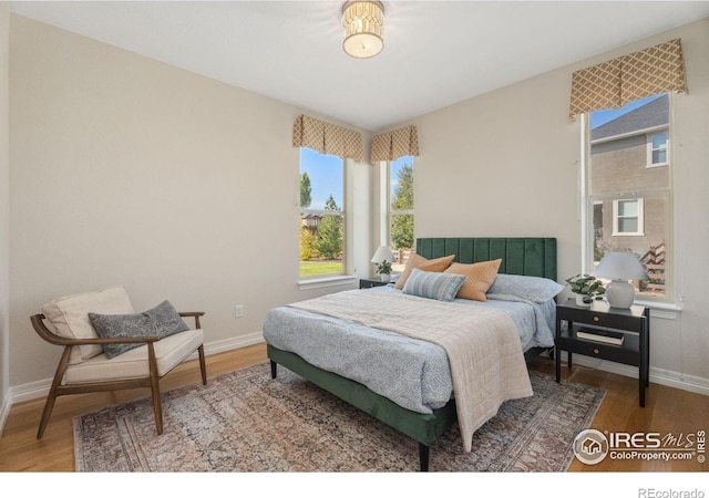 bedroom with baseboards and wood finished floors