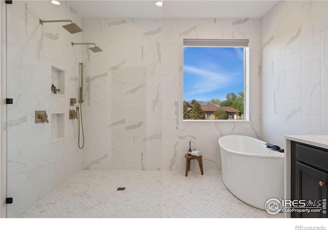 bathroom featuring vanity, tile walls, a marble finish shower, and a freestanding bath