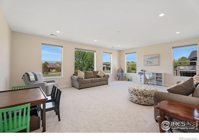 carpeted living area featuring plenty of natural light, recessed lighting, visible vents, and baseboards