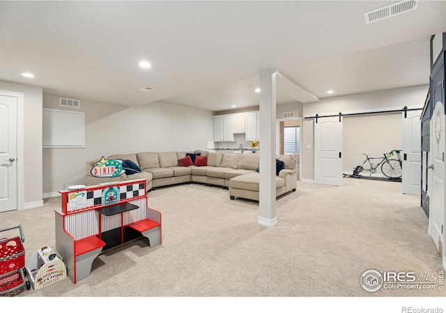 carpeted living area featuring a barn door, recessed lighting, visible vents, and baseboards