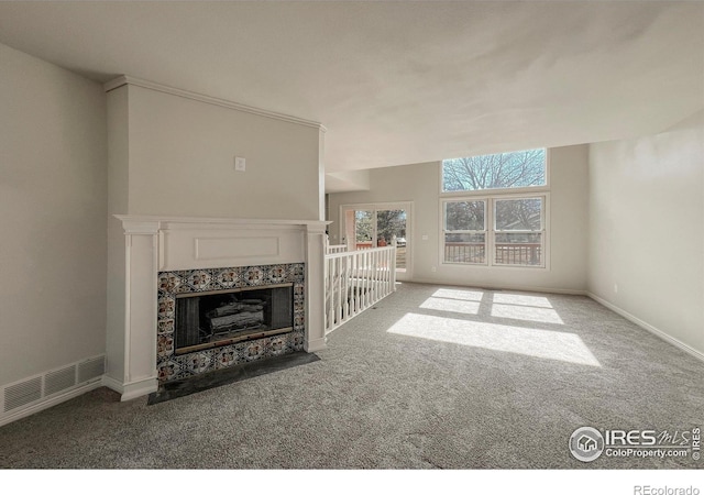 unfurnished living room featuring carpet floors, visible vents, baseboards, and a premium fireplace