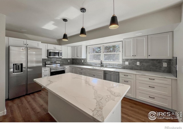 kitchen with appliances with stainless steel finishes, backsplash, a sink, and white cabinets