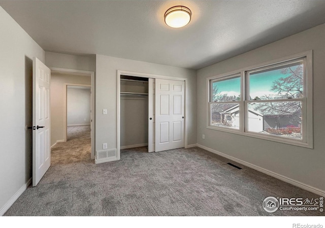 unfurnished bedroom with baseboards, visible vents, and carpet flooring