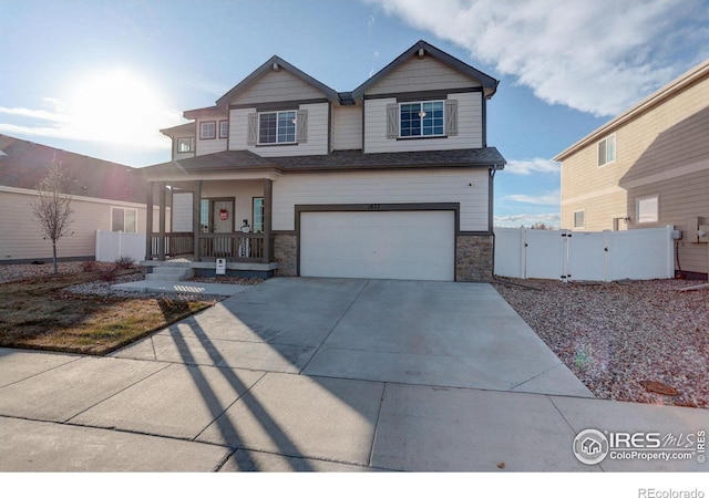 craftsman inspired home with concrete driveway, an attached garage, a gate, fence, and a porch