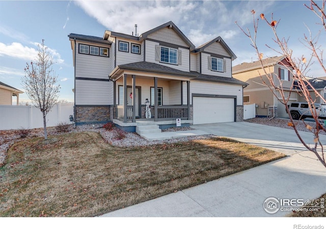 view of front of home with a porch, fence, a garage, stone siding, and driveway