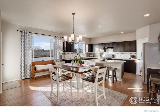 dining area with recessed lighting, a notable chandelier, baseboards, and wood finished floors